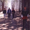 Quatre personnes qui marchent sur un sentier en forêt.