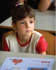Écolière assise à son pupitre dans une salle de classe.