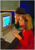Une fille et un garçon devant un ordinateur.
