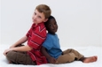 Un enfant de race blance et un enfant de race noire assis dos à dos.