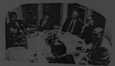 Femmes et hommes assis autour d'une table pour le repas.